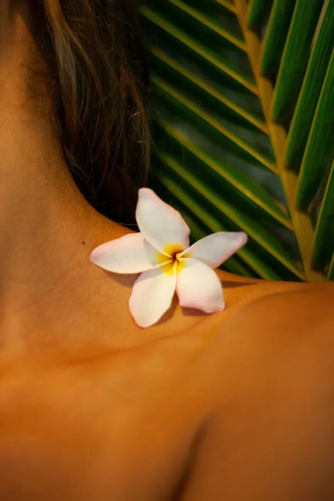 Woman With White Flower on Her Neck