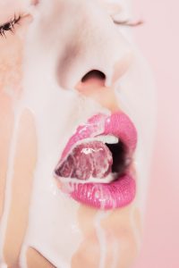 a close up of a woman's face with pink lipstick
