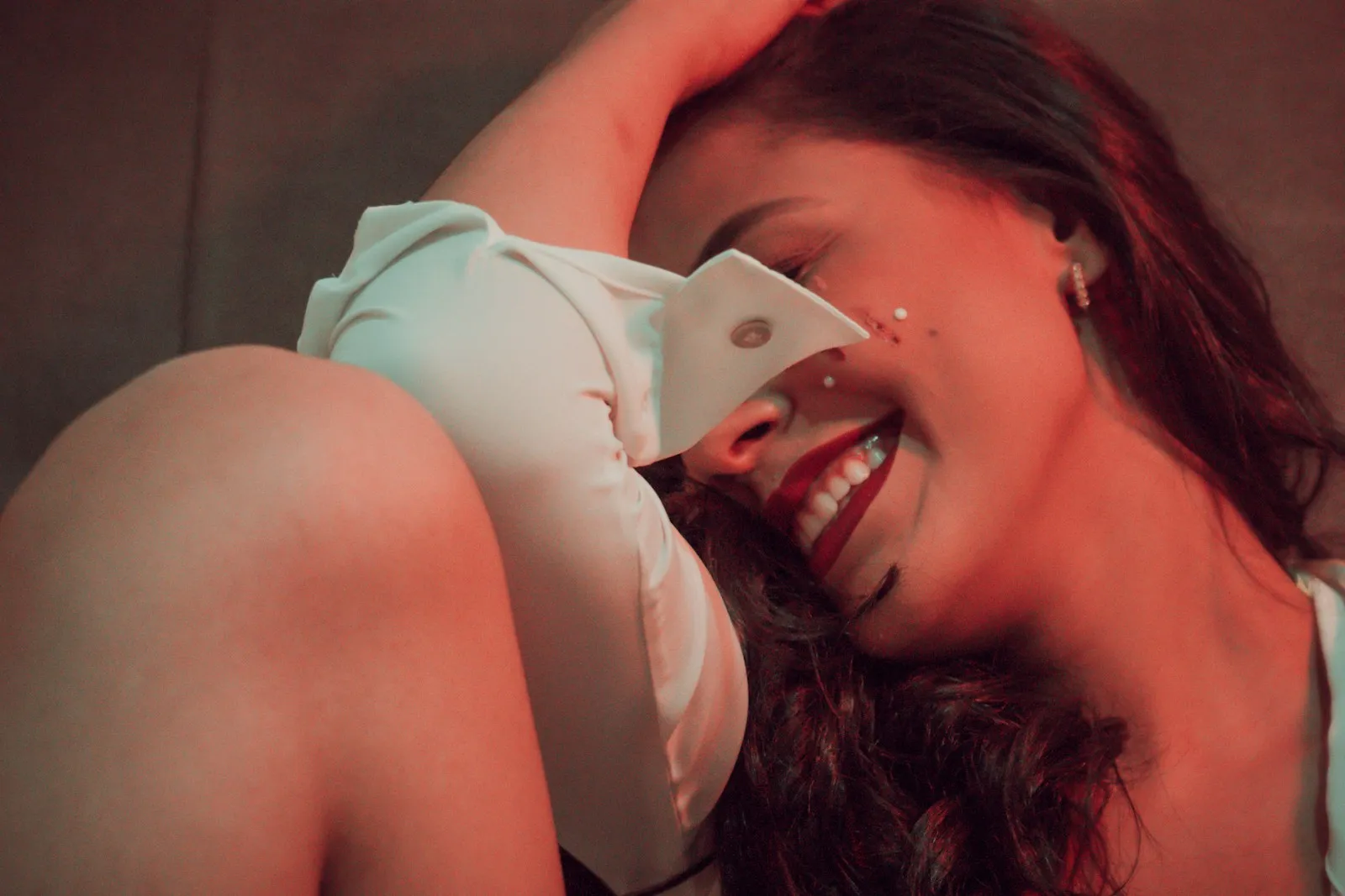 a woman laying on a couch holding a cell phone to her ear